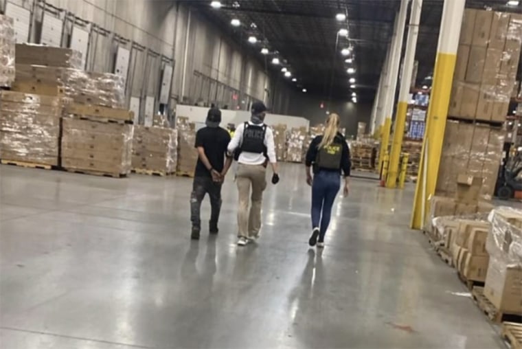 Officers arresting people inside a warehouse.