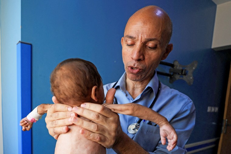 Palestinian doctor Ahmed Basal examines a child for malnutrition at Al-Rantisi Hospital in Gaza City