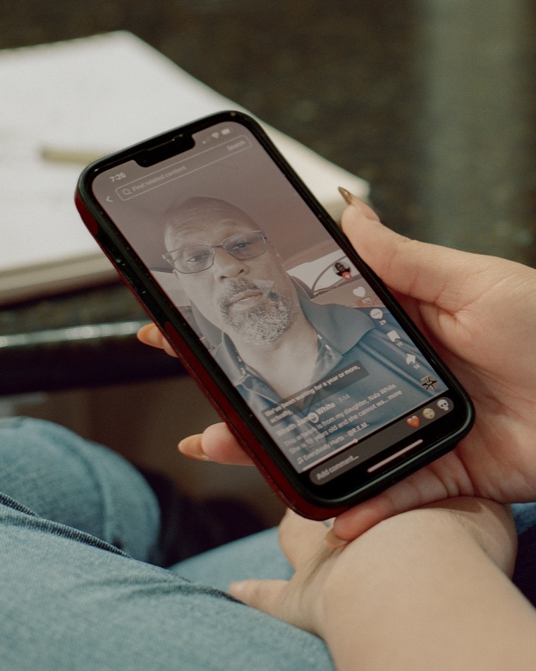 A hand holds a phone showing a video of Wrath James White