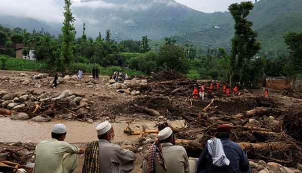 Residents watch as Urban Search and Rescue personnel recover bodies from the rubble of storm-hit homes in Bayshonai Kalay, Buner district, Khyber Pakhtunkhwa, on August 17, 2025.