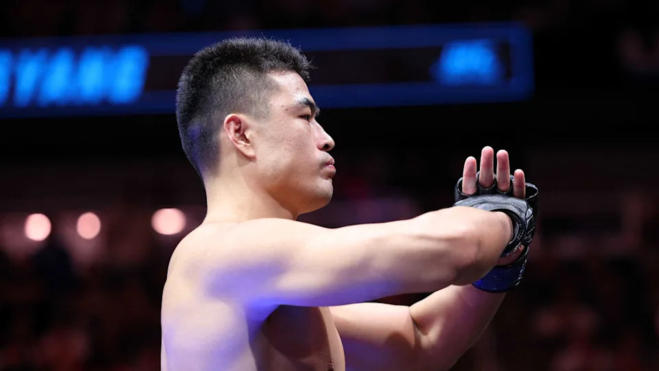 Apr 26, 2025; Kansas City, Missouri, UNITED STATES; Zhang Mingyang (blue gloves) reacts after defeating Anthony Smith (not pictured) during UFC Fight Night at T-Mobile Center. Mandatory Credit: William Purnell-Imagn Images